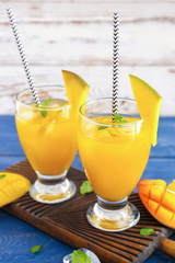 Glasses of fresh mango juice on table