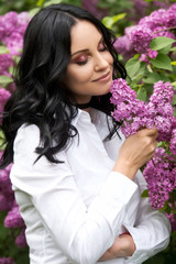 Beautiful woman in lilac garden.