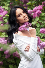 Beautiful woman in lilac garden.