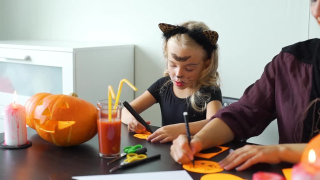 Mother and Little Daughter Making Halloween Decorations at Home. Slow Motion. Halloween Holiday Concept