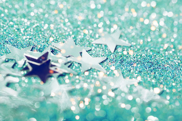 Light green festive background with sparkles in the bokeh and small stars. The concept of the celebration, the day of New Year, birthdays, ceremonies, events, etc.