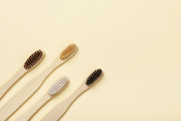 Four eco-friendly bamboo toothbrushes on a yellow background. Zero waste concept, plastic-free, organic, eco-friendly shopping