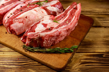 Raw pork ribs with spices and rosemary on wooden table