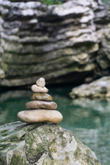 Harmony, balance and simplicity concept. A stone pyramid on the background of river water. Simple poise pebbles, rock zen sculpture