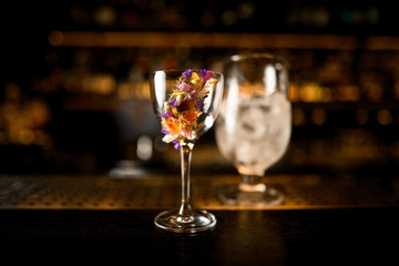 Close-up of alcohol cocktail and glass with ice on a counter