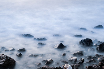 Beautiful stones, rocks and sea in a mystical haze at sunset. Long exposure. cool light landscape. Turkey. Aegean sea shore.