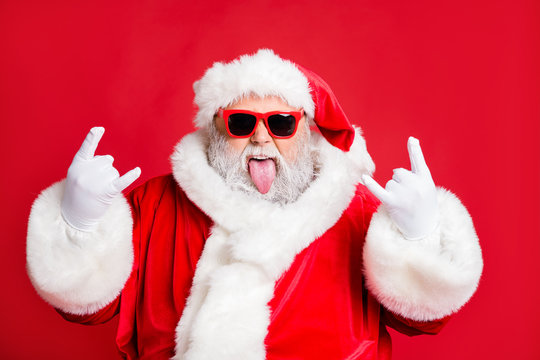 Close-up portrait of his he nice attractive positive playful bearded Santa having fun leisure showing horns symbol sign heavy metal fest isolated over bright vivid shine red background
