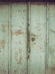 Background image of the green door of an old rusted garage