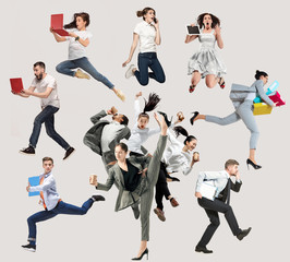 Happy office workers jumping and dancing in casual clothes or suit with folders, coffee, tablet on...