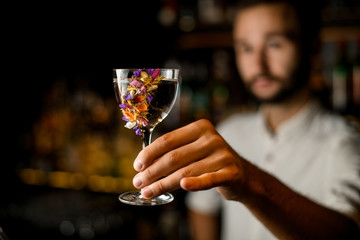 Bartender with beard holding alcohol in glass
