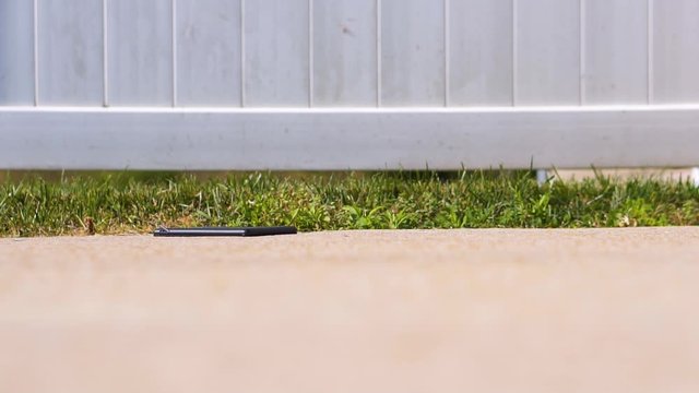 Touchscreen tablet falling on concrete in slow motion