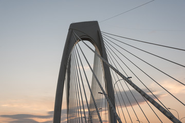 Obraz premium Concrete cable-stayed bridge steel net under dusk fire clouds background