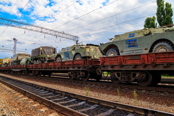 Obraz premium Cargo train carrying military vehicles on railway flat wagons