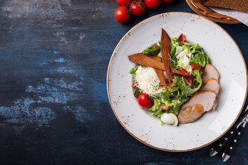 Caesar salad with chicken and vegetables. Copy space. Top view