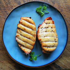 Grilled chicken breast on dark wooden background