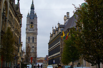 Botermarkt, one of the main streets in the old town of Ghent, Belgium, Europe, with the Town Hall on the right side and the Belfry (Bell tower or Het Belfort) at the background