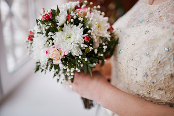 bride holds a wedding bouquet in her hands