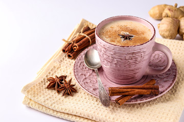 Traditional indian drink - masala tea with spices in pink cup on a white background, horizontal orientation, copy space