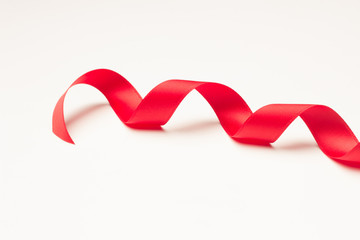 Cinta roja sobre fondo blanco para hacer lazos y decorar los regalos de navidad, regalos de anniversario, regalos en general.