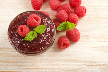 raspberries jam on wooden background