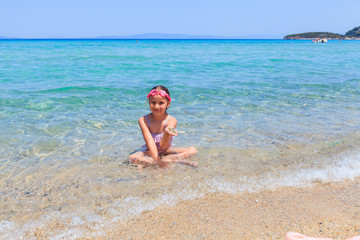 Happy little girl enjoy on sandy beach during summer vacation