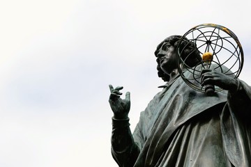 The Nicolaus Copernicus Monument in Torun - home town of astronomer Nicolaus Copernicus. Torun, Poland.  Close up, place for text - obrazy, fototapety, plakaty