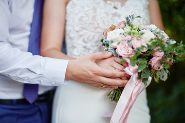 Obraz na płótnie Canvas bride holds a wedding bouquet in her hands