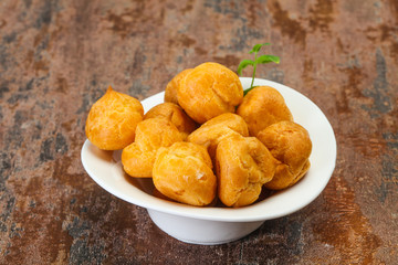 Sweet tasty profiteroles heap in the bowl