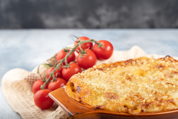 Traditional italian cannelloni with vegetables, minced meat and cheese. On a wooden background. Top view, copy space