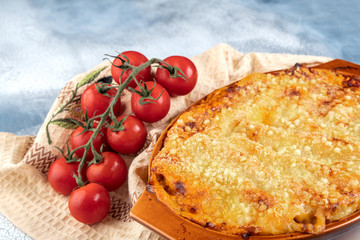 Traditional italian cannelloni with vegetables, minced meat and cheese. On a wooden background. Top view, copy space
