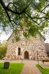 Fototapeta na wymiar Hollola, Finland - 9 September 2019: Old medieval stone church of St. Mary in Hollola, Finland