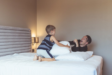 Fototapeta na wymiar Happy father and son having fun in the bedroom.