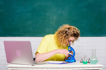 Microbiology concept. Student girl with laptop and microscope. Molecular biology PhD projects....