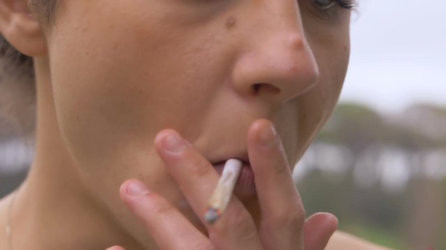 close up on Young woman smoking joint.smoking, hashish, marijuana,light drug