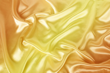 Fototapeta premium miękkie fałdy na delikatnym żółtym błyszczącym jedwabiu, luksusowa koncepcja, tło dla projektanta, poziome, zbliżenie, kopia przestrzeń