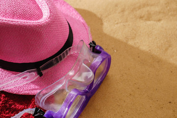 Top view of sandy beach with towel frame and summer accessories. Background with copy space and sand texture.