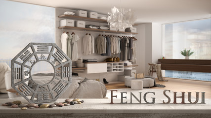 Vintage wooden table shelf with pebble balance and 3d letters making the word feng shui over modern white and wooden bedroom in contemporary apartment, zen concept interior design