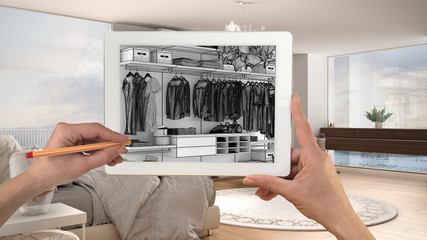 Hands holding and drawing on tablet showing modern white bedroom with wooden details CAD sketch. Real finished interior in the background, architecture design presentation
