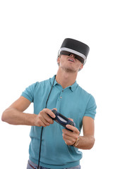 Caucasian young boy playing with reality glasses and virtual console controller dressed in a blue polo shirt isolated in white background