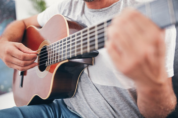Man playing acoustic guitar in the living room.