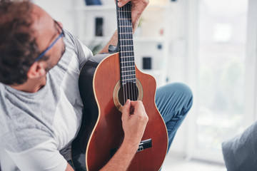 Man playing acoustic guitar in the living room.