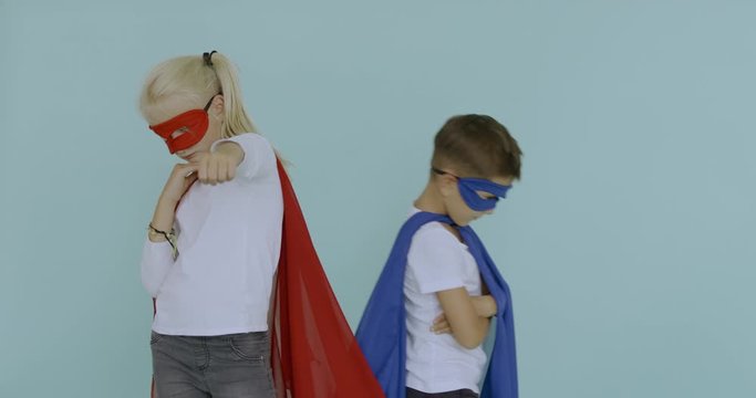 120 FPS SLOW MOTION Cute funny little Caucasian kids boy and girl wearing capes and masks pretending to be superheroes. 4K UHD