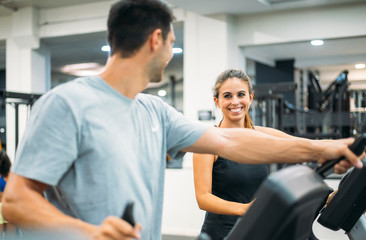 Adult couple is working out on Step climber machine in fitness gym for healthy lifestyle concept.