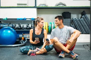 Middle-aged couple with the phone in gym