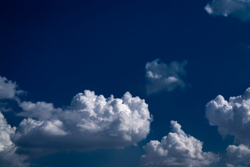 White gray clouds against a background of blue sky. Horizontal orientation.