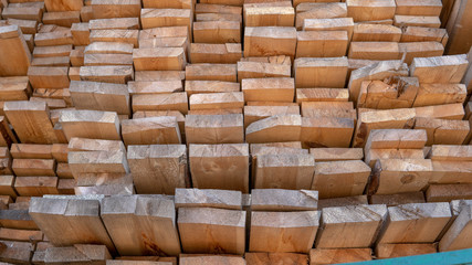 Wooden boards, lumber, industrial wood, timber. Pine wood timber stack of natural rough wooden boards on building site. Industrial timber building materials