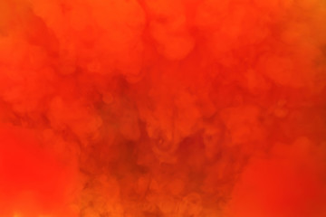 Paints dissolved in water with a beautiful spectacular blur. Trending neon orange colors. Bright amazing abstract background. Smoke effect..