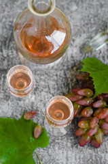 Traditional Italian grappa or liquor and grape.  Wine and grape.