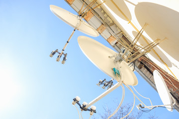 A lot of satellite dishes mounted on the wall.