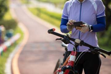 Riding on bike path,using smartphone while riding bike on sunny day